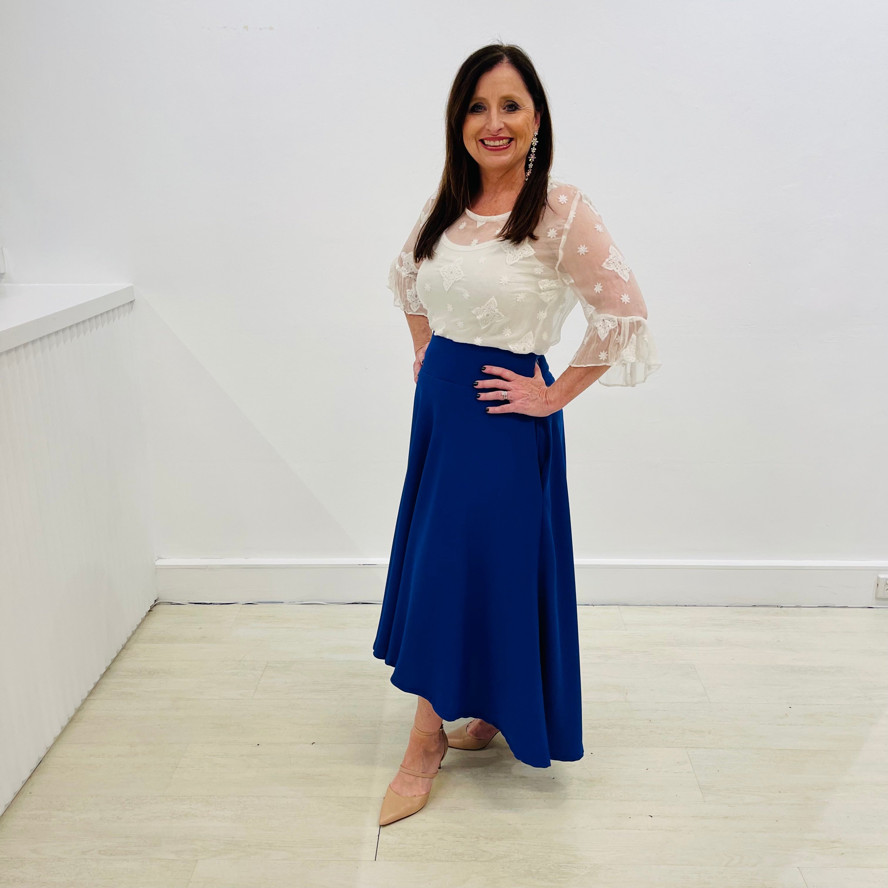 Royal blue,full circle skirt, with dipped hemline at back, wide flat waistband, with zipper opening and side seam pockets. White embroidered silk chiffon, round neckline, ruffle sleeve, relaxed fit women's blouse.