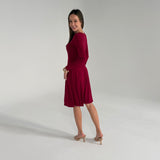 Woman wearing a burgundy dress on a plain background