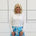 Relaxed, loose line fit, white bamboo, long sleeve with cuff and waistband shape, round neckline top. With blue skirt 