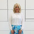 Relaxed, loose line fit, white bamboo, long sleeve with cuff and waistband shape, round neckline top. With blue skirt 