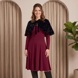 Woman wearing a burgundy dress with a black fur shrug in a neutral setting