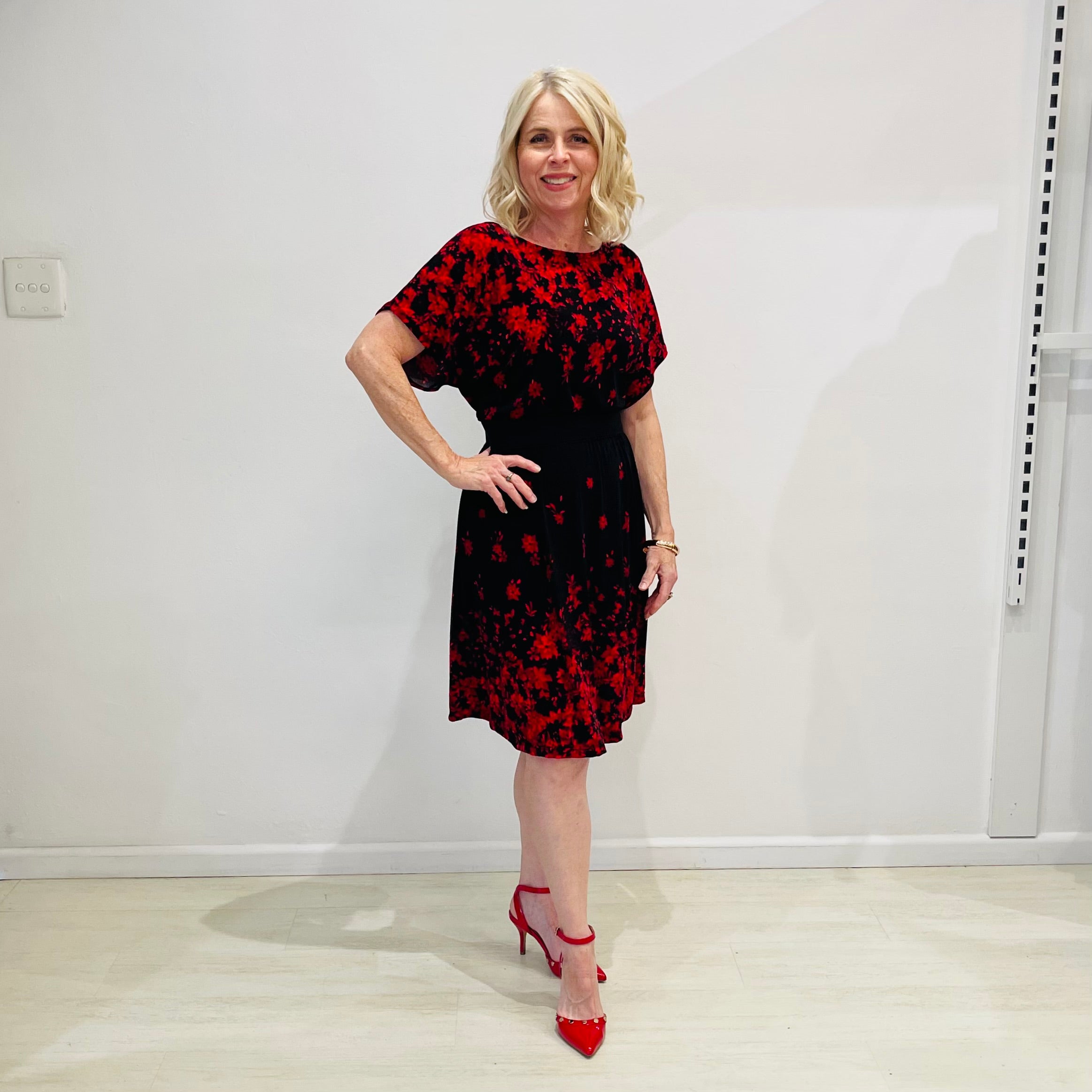 Black base colour dress with red floral border print on neckline and hemline. Short sleeve & knee length dress. 
