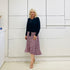 Relaxed fit, black bamboo, v neckline, long sleeve, tie front detail, dressy top. Worn with midi length skirt with slight hemline ruffle in black,white and pink. 