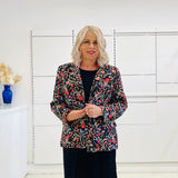 Black silk, with floral embroidery, collar, lapels, 3 button front closure, with pockets jacket. Worn with dressy straight black dress with side seam splits.