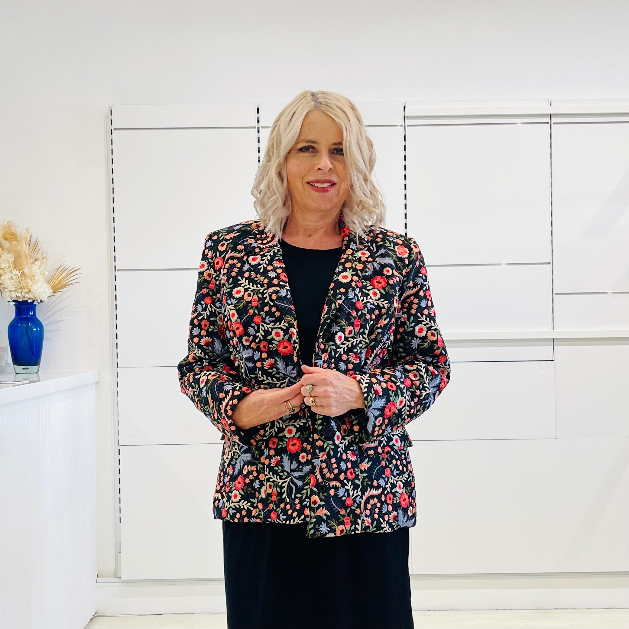 Black silk, with floral embroidery, collar, lapels, 3 button front closure, with pockets jacket. Worn with dressy straight black dress with side seam splits.