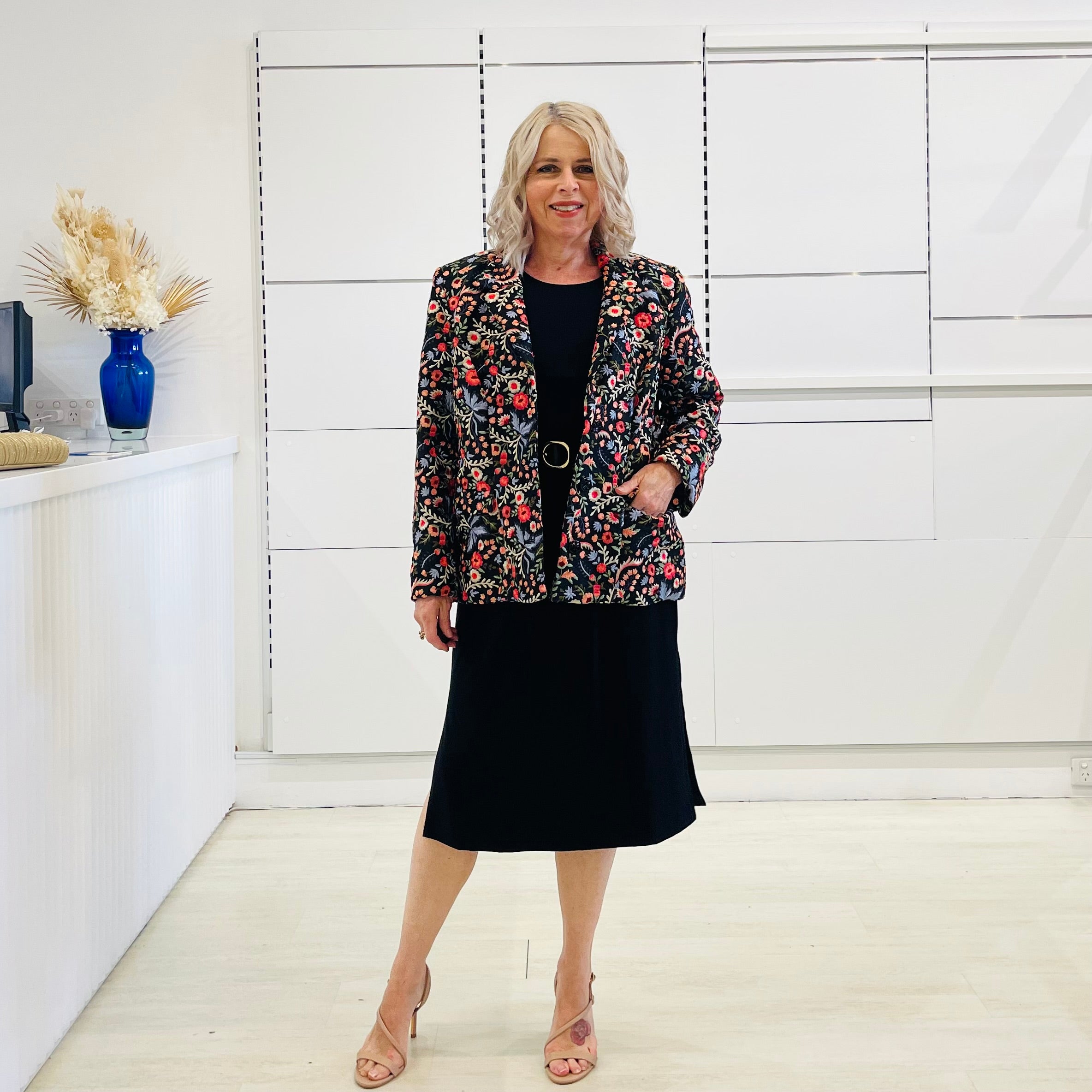 Black silk, with floral embroidery, collar, lapels, 3 button front closure, with pockets jacket. Worn with dressy straight black dress with side seam splits.