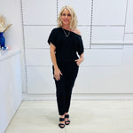 Black, textured fabric with subtle  Jaguar design pattern,  tapered leg pant with, pockets, stretch waistband, side seam invisible zipper opening. Black off the shoulder top.