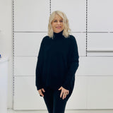 Relaxed fit loose line, long line, long sleeved, black knit jumper/sweater. With black pants and knee high leather boots 