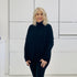 Relaxed fit loose line, long line, long sleeved, black knit jumper/sweater. With black pants and knee high leather boots 