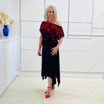 Black & red floral print, off the shoulder, asymmetrical neckline, relaxed fit top, worn with black, handkerchief hemline skirt with elastic waistband.