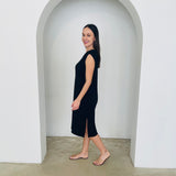 Woman in a black dress standing in a white archway