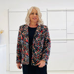 Black silk, with floral embroidery, collar, lapels, 3 button front closure, with pockets jacket. Worn with dressy straight black dress with side seam splits.