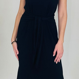 Black dress worn by a person on a plain background
