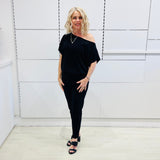 Black, textured fabric with subtle  Jaguar design pattern,  tapered leg pant with, pockets, stretch waistband, side seam invisible zipper opening. Black off the shoulder top.