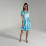 Woman wearing a blue and white patterned dress on a gray background