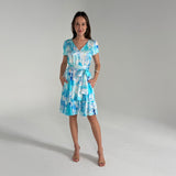 Woman wearing a blue and white patterned dress on a gray background