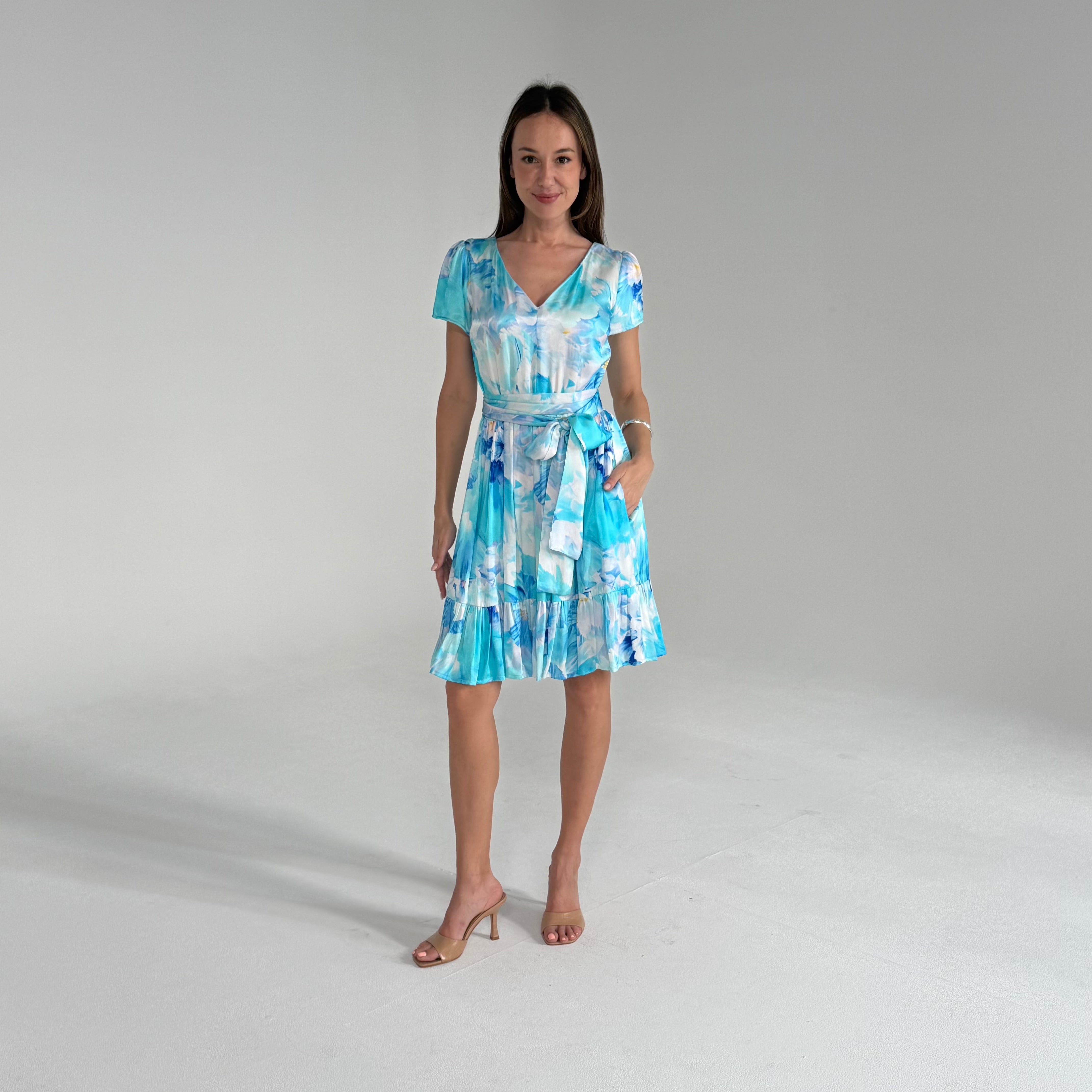 Woman wearing a blue and white patterned dress on a gray background