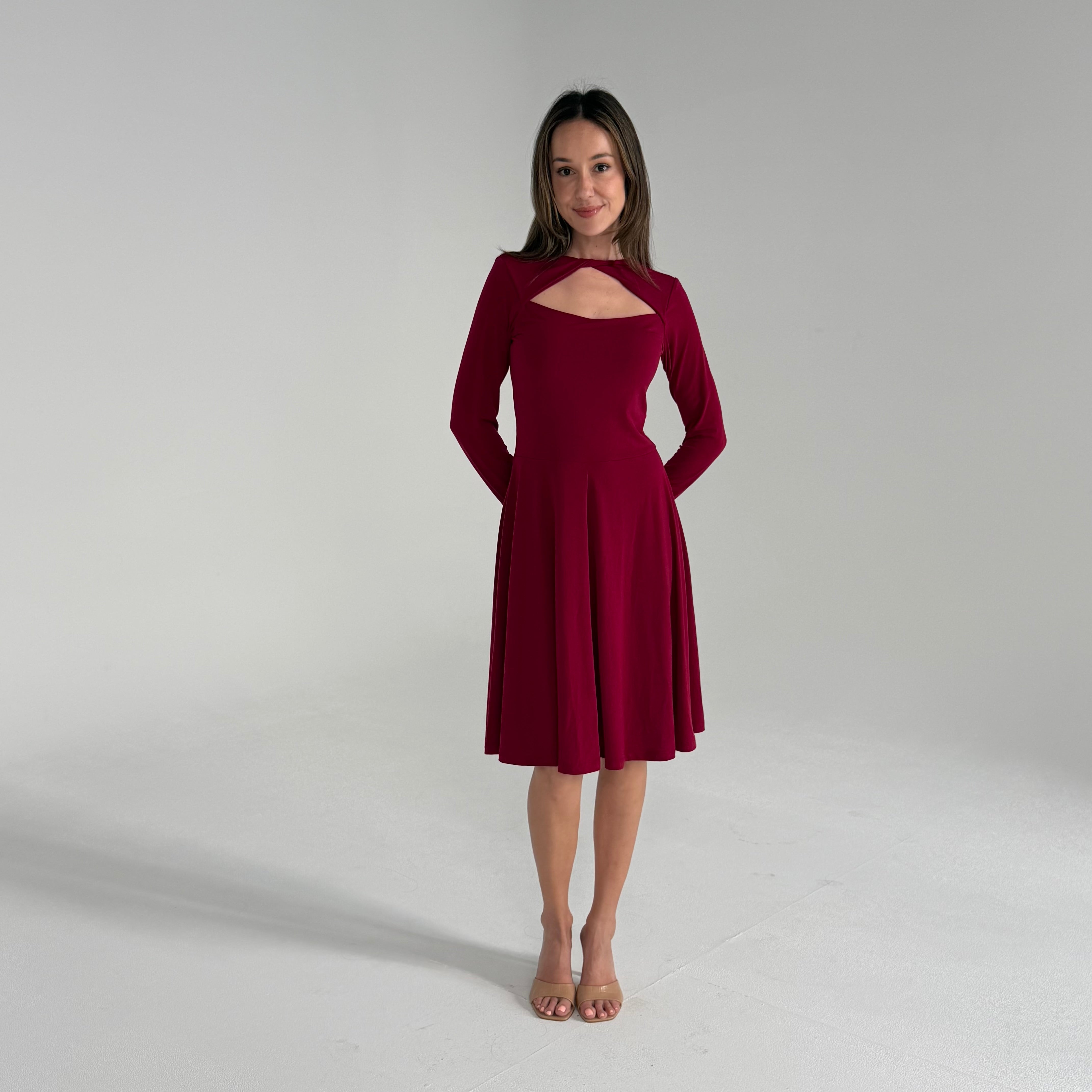 Woman wearing a burgundy dress against a plain background