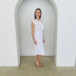Woman in a white dress standing in a white archway