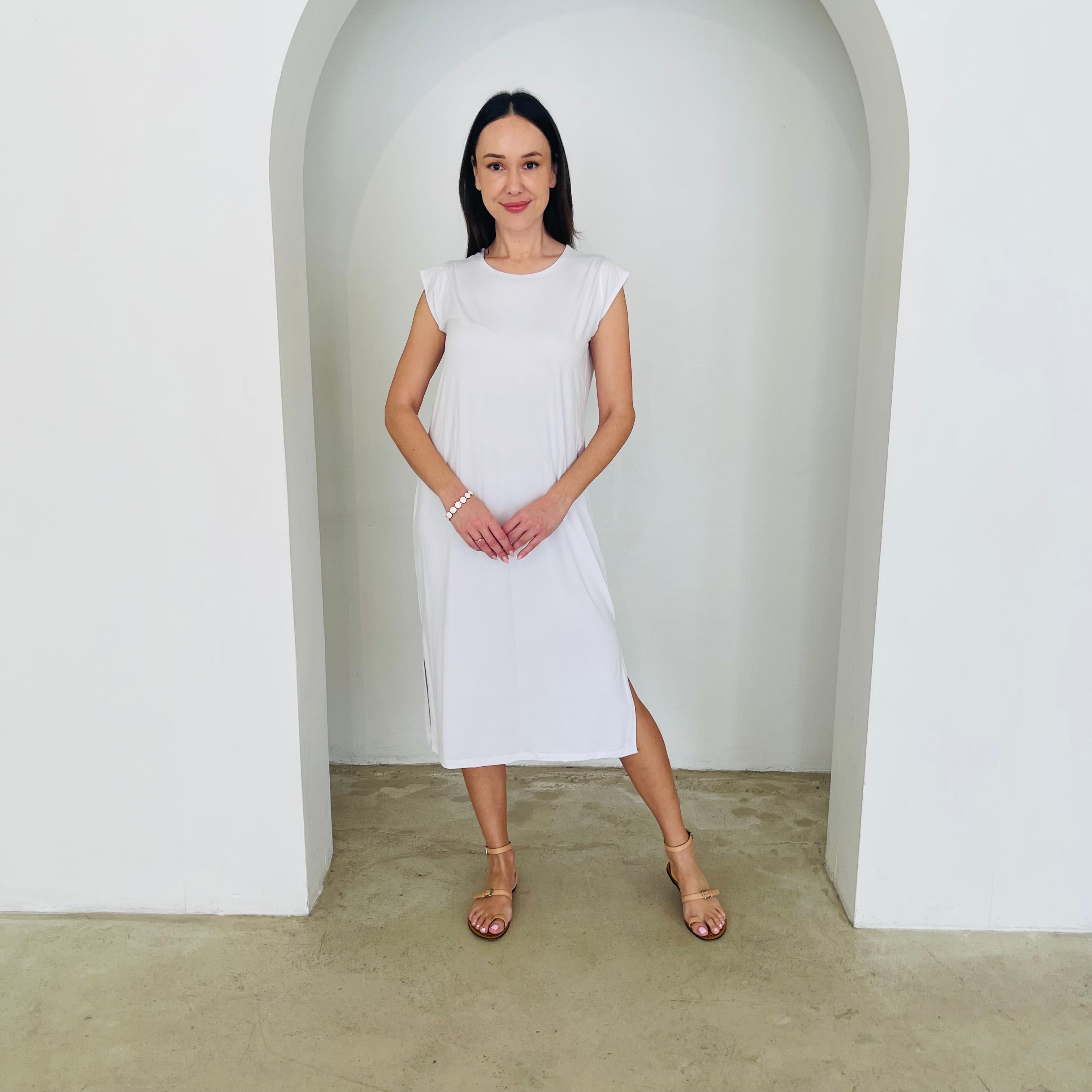 Woman in a white dress standing in a minimalistic setting