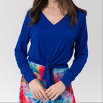 Woman in blue top and long colourful skirt