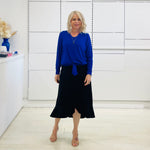 Relaxed fit, cobalt blue bamboo, v neckline, long sleeve, tie front detail, dressy top. Worn with midi length skirt with slight hemline ruffle in black.