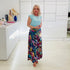 Woman wearing blue t shirt with long floral skirt. 