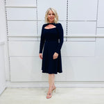 Penelope dress in deep navy blue, worn by model- elegant long sleeve design, knee length, with modern neckline.