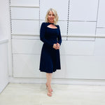 Side view, Penelope dress in deep navy blue, worn by model- elegant long sleeve design, knee length, with modern neckline.