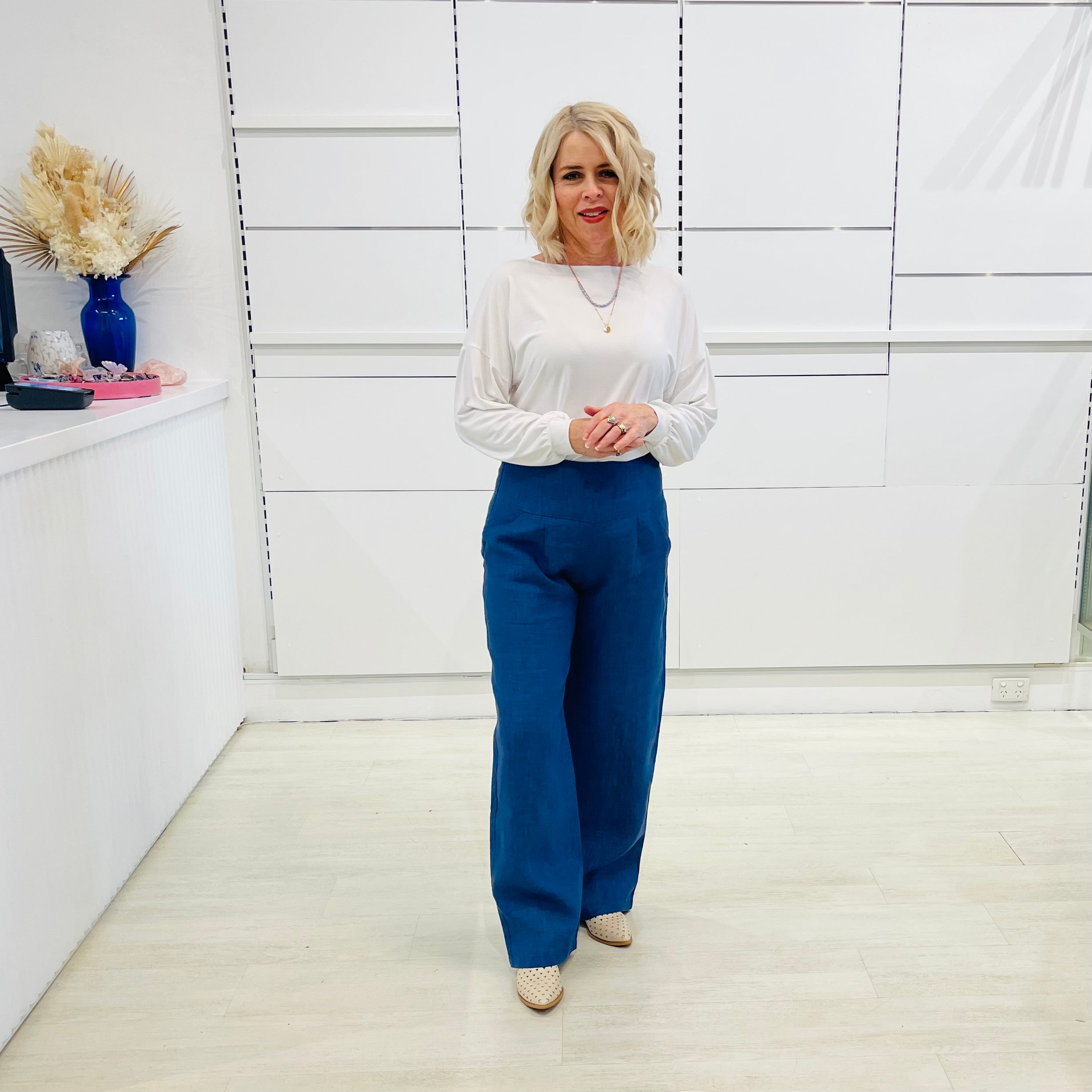 Denim blue,wide leg linen pants with flat waistband, zipper opening and pockets,worn with white bamboo, relaxed fit, long sleeve Gracie top.