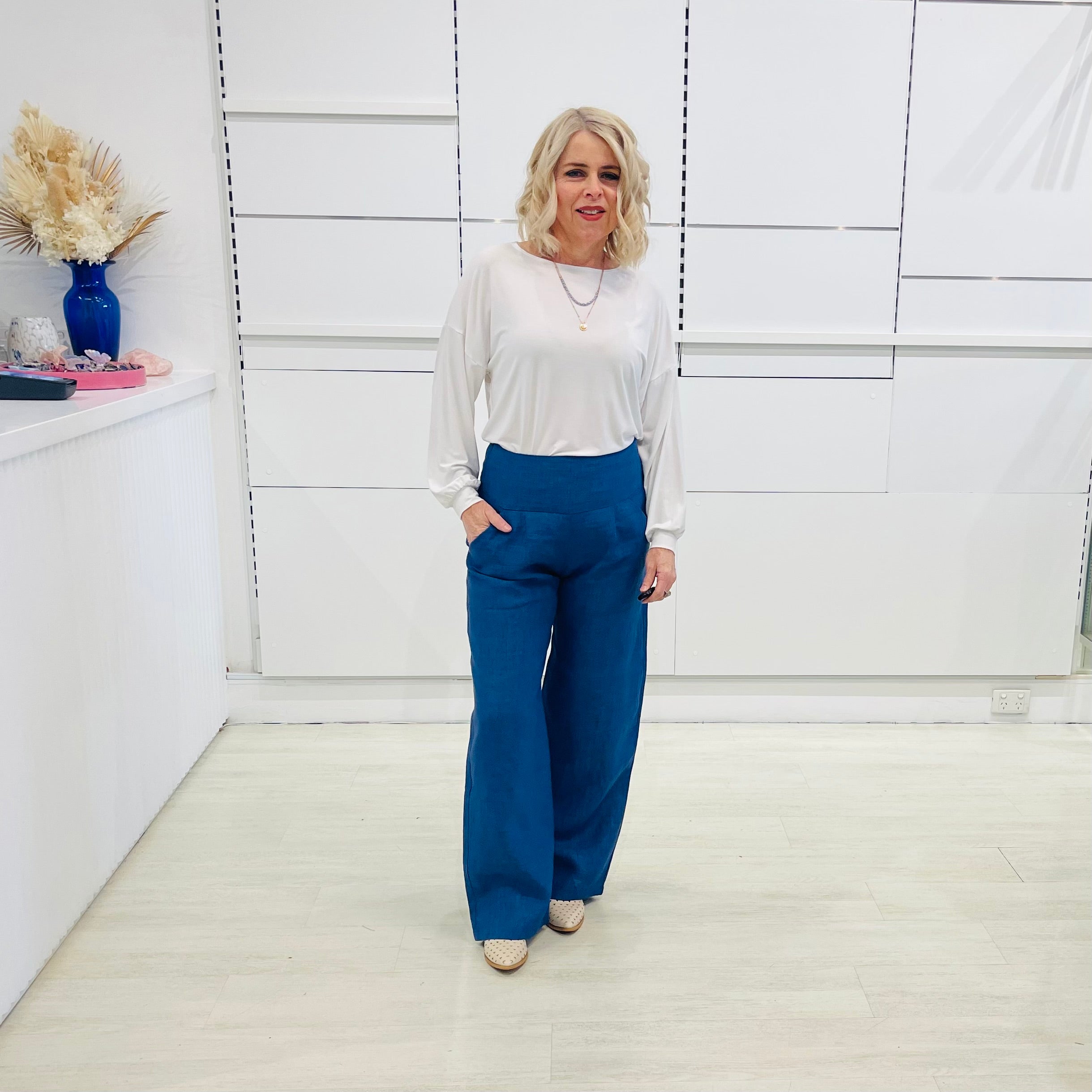 Denim blue,wide leg linen pants with flat waistband, zipper opening and pockets,worn with white bamboo, relaxed fit, long sleeve Gracie top.