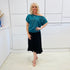 Stunning off the shoulder emerald green top with delicate shimmer. Flattering relaxed fit cut with stretch waistband for style and fit. Worn with black stretch skirt with asymmetrical hemline small ruffle detail.