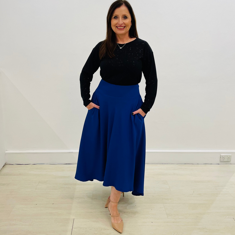 Black, round neckline, long sleeve, loose line, relaxed fit, women's blouse|top with shimmery glitter sparkle, evening top.Worn with midi length, cobalt blue , fitted waistband skirt with pockets and uneven hemline detail.