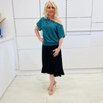Stunning off the shoulder emerald green top with delicate shimmer. Flattering relaxed fit cut with stretch waistband for style and fit. Worn with black stretch skirt with asymmetrical hemline small ruffle detail.