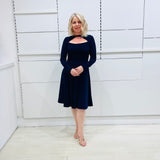 Penelope dress in deep navy blue, worn by model- elegant long sleeve design, knee length, with modern neckline.