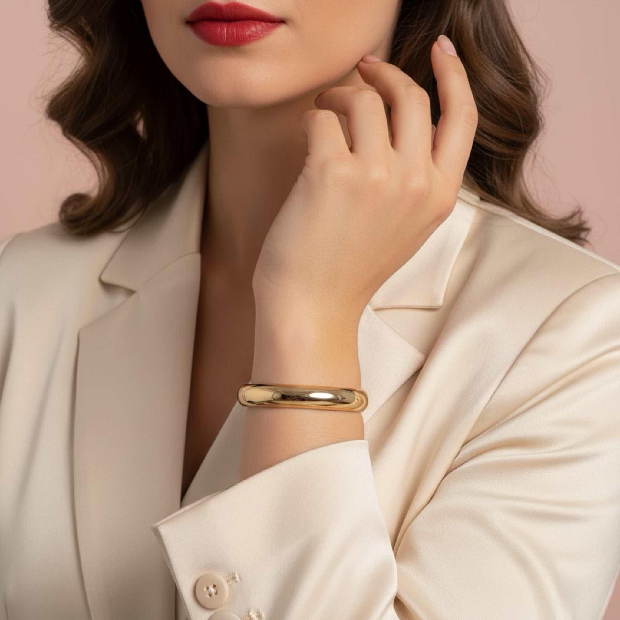 Woman wearing a gold bracelet with a neutral background