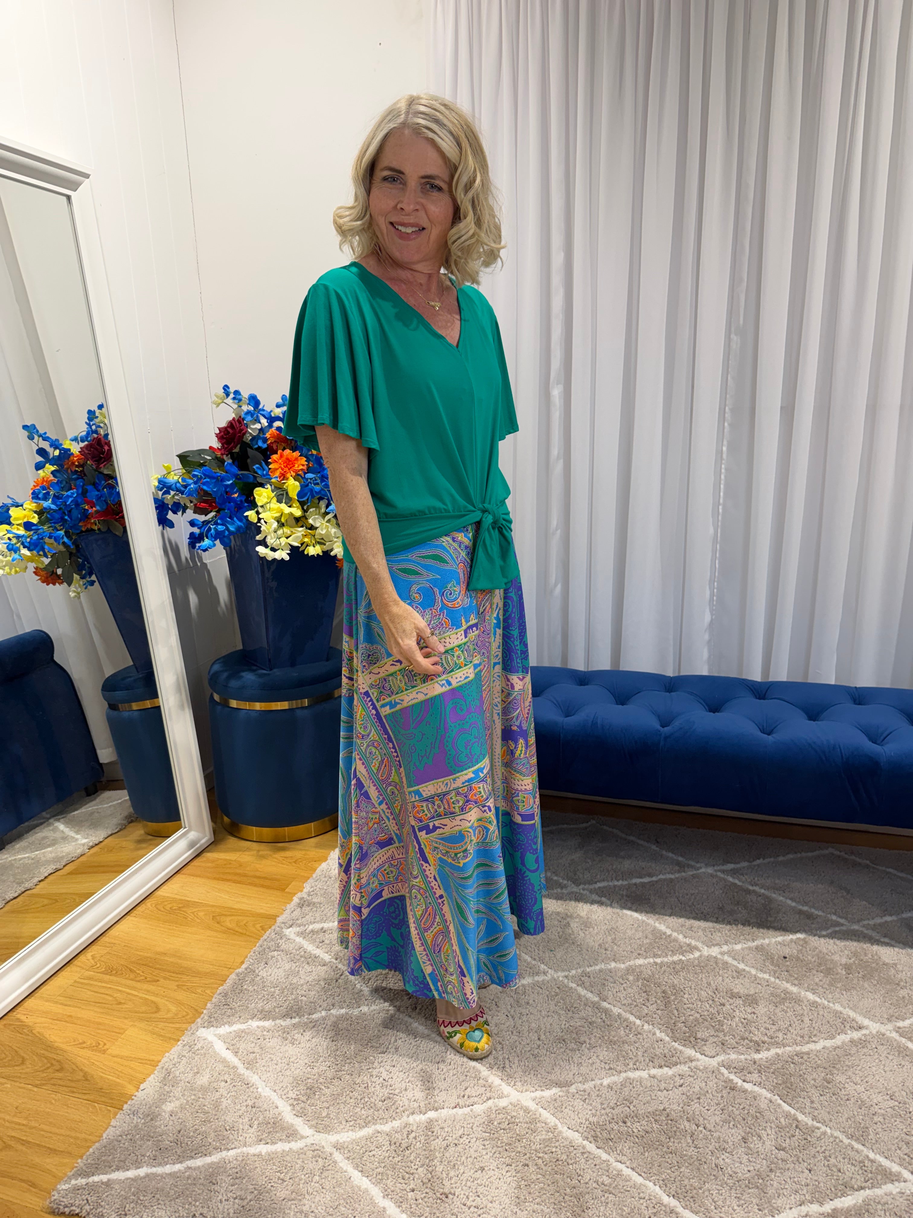Woman wearing Harper top green and colourful skirt 