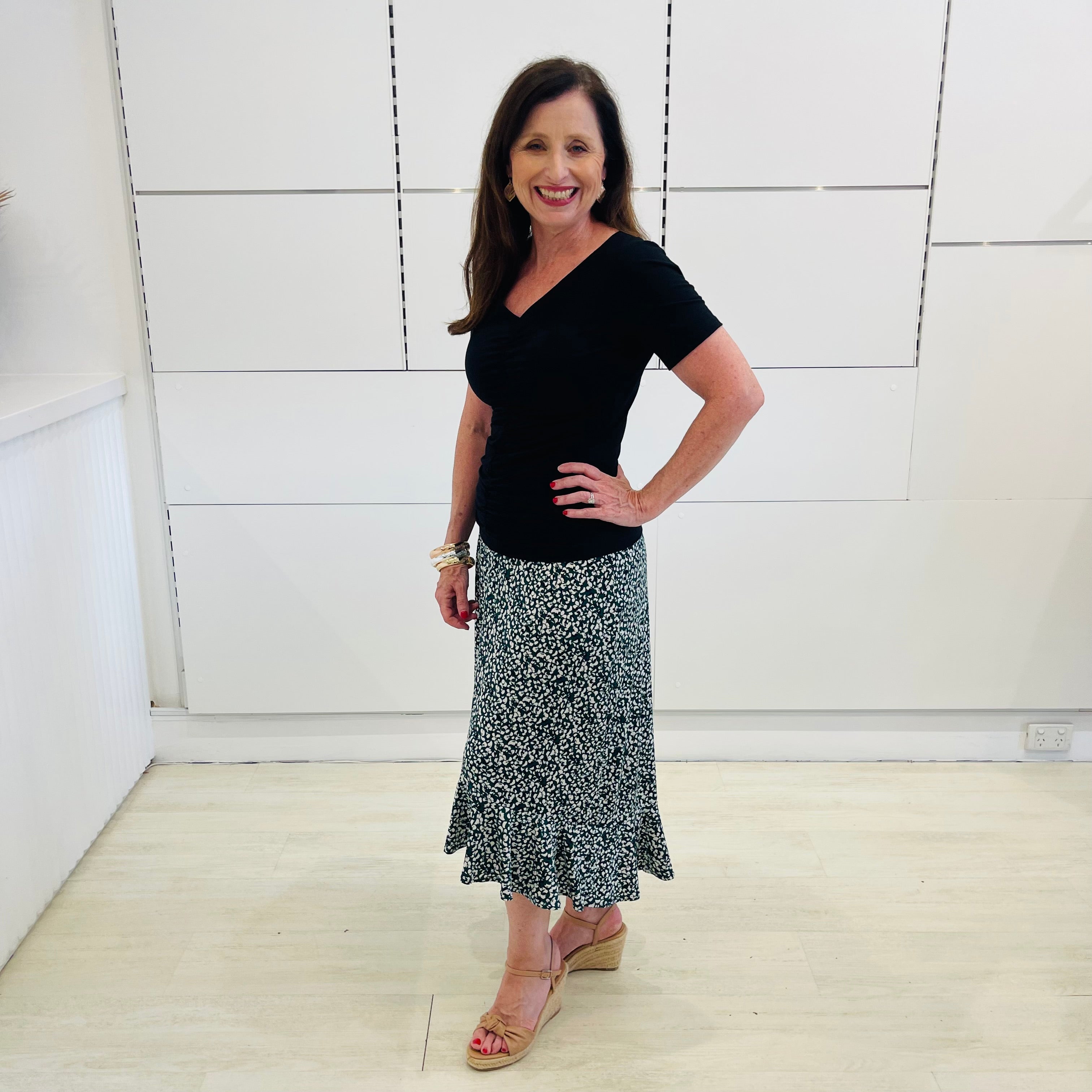 Green,black and white print, stretch, slight a-line skirt, with small ruffle on hemline. Worn with black bamboo, short sleeve top.