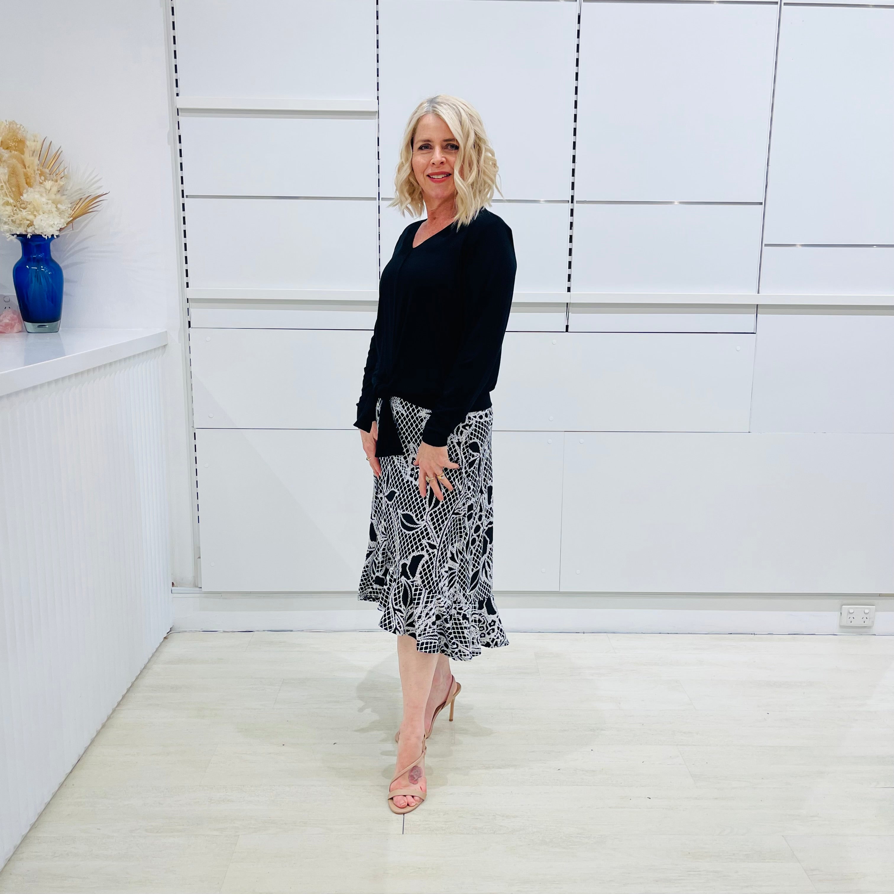 Noir garden-Black and white floral print, Rachel  Ruffle skirt, with elastic stretch waist. Worn on model with black bamboo , long sleeve, tie front, v-neckline top.
