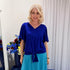 Woman wearing blue top and green skirt 