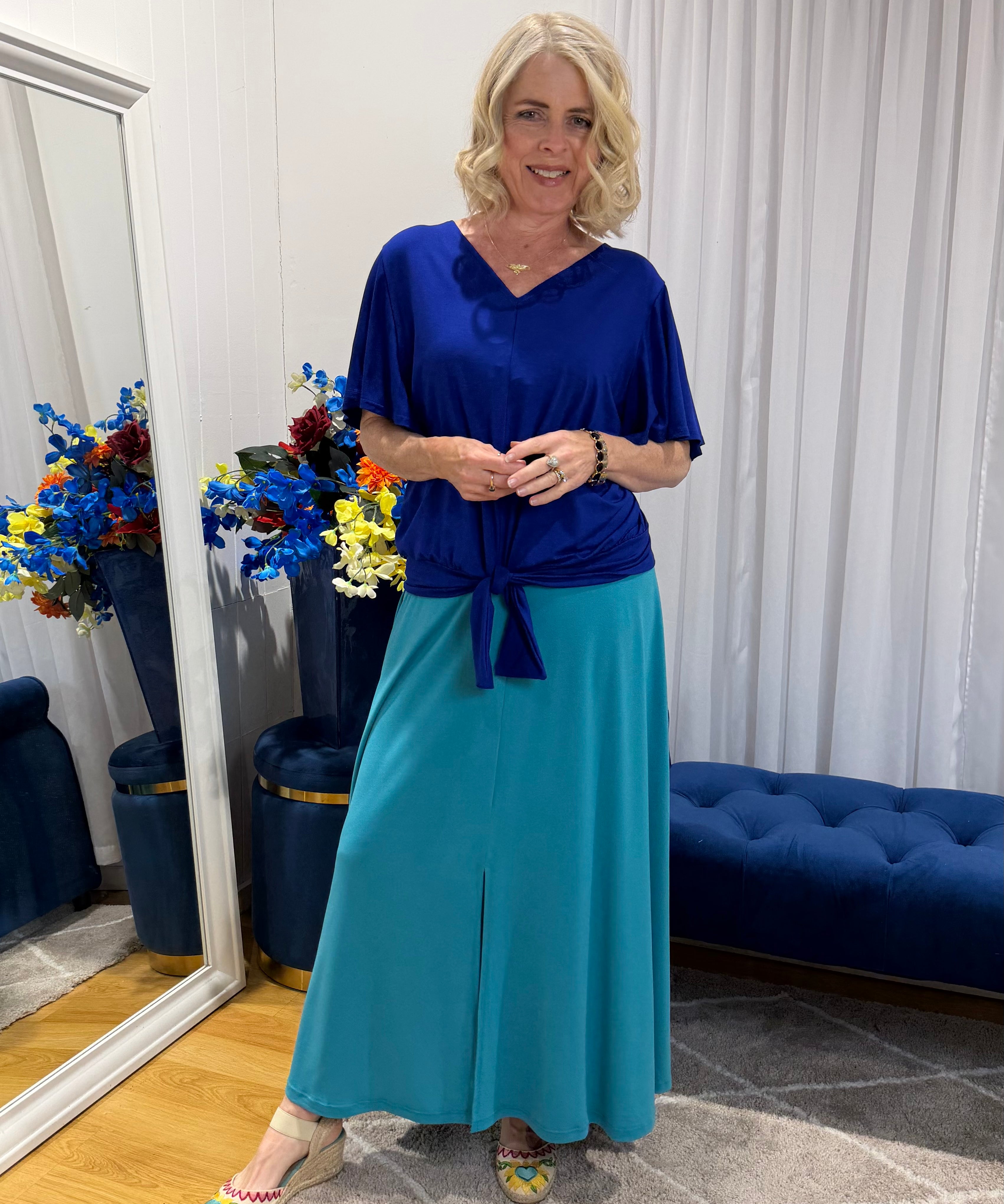 Woman wearing blue top and green skirt 