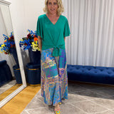 Woman wearing Harper top green and colourful skirt 