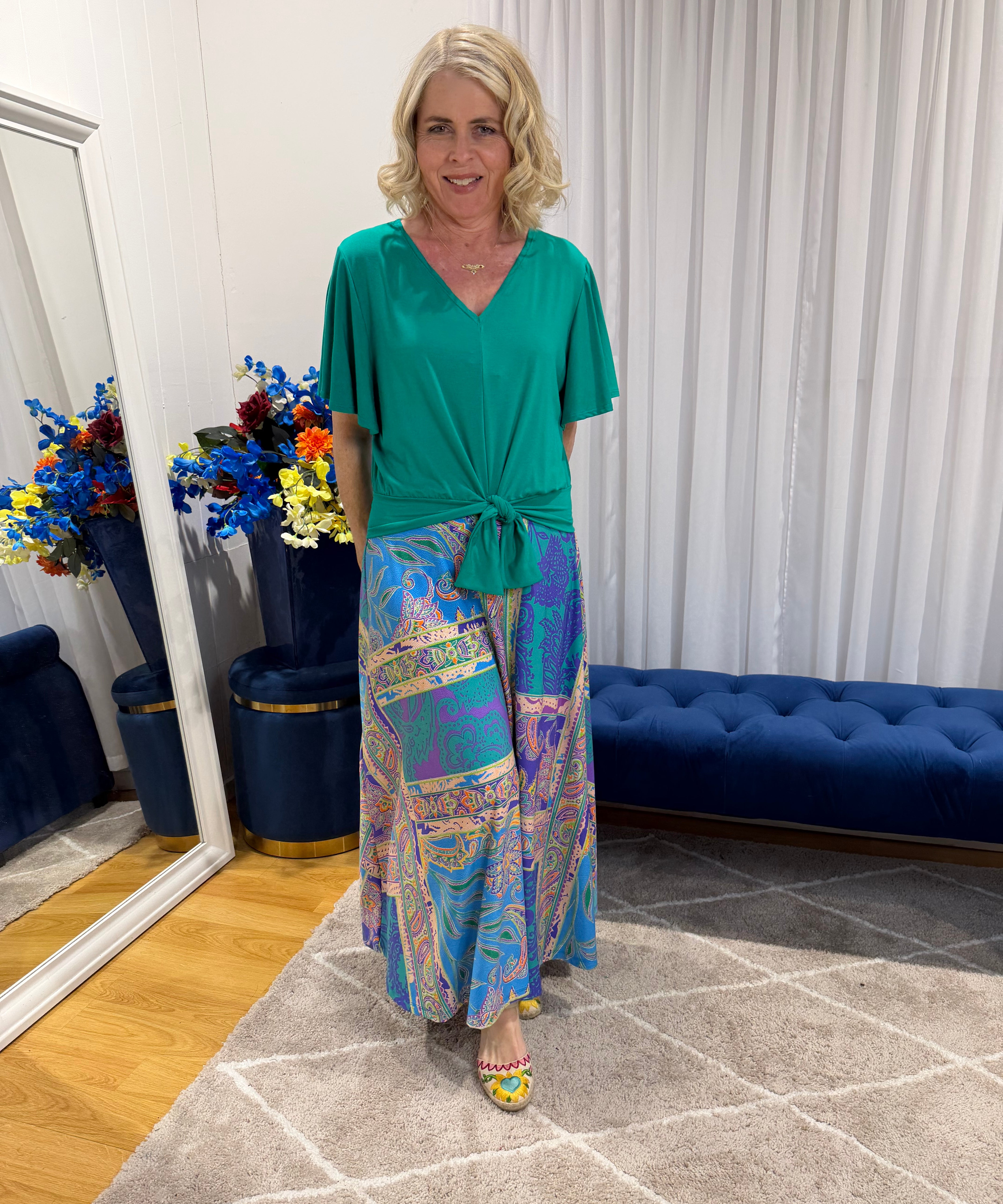 Woman wearing Harper top green and colourful skirt 