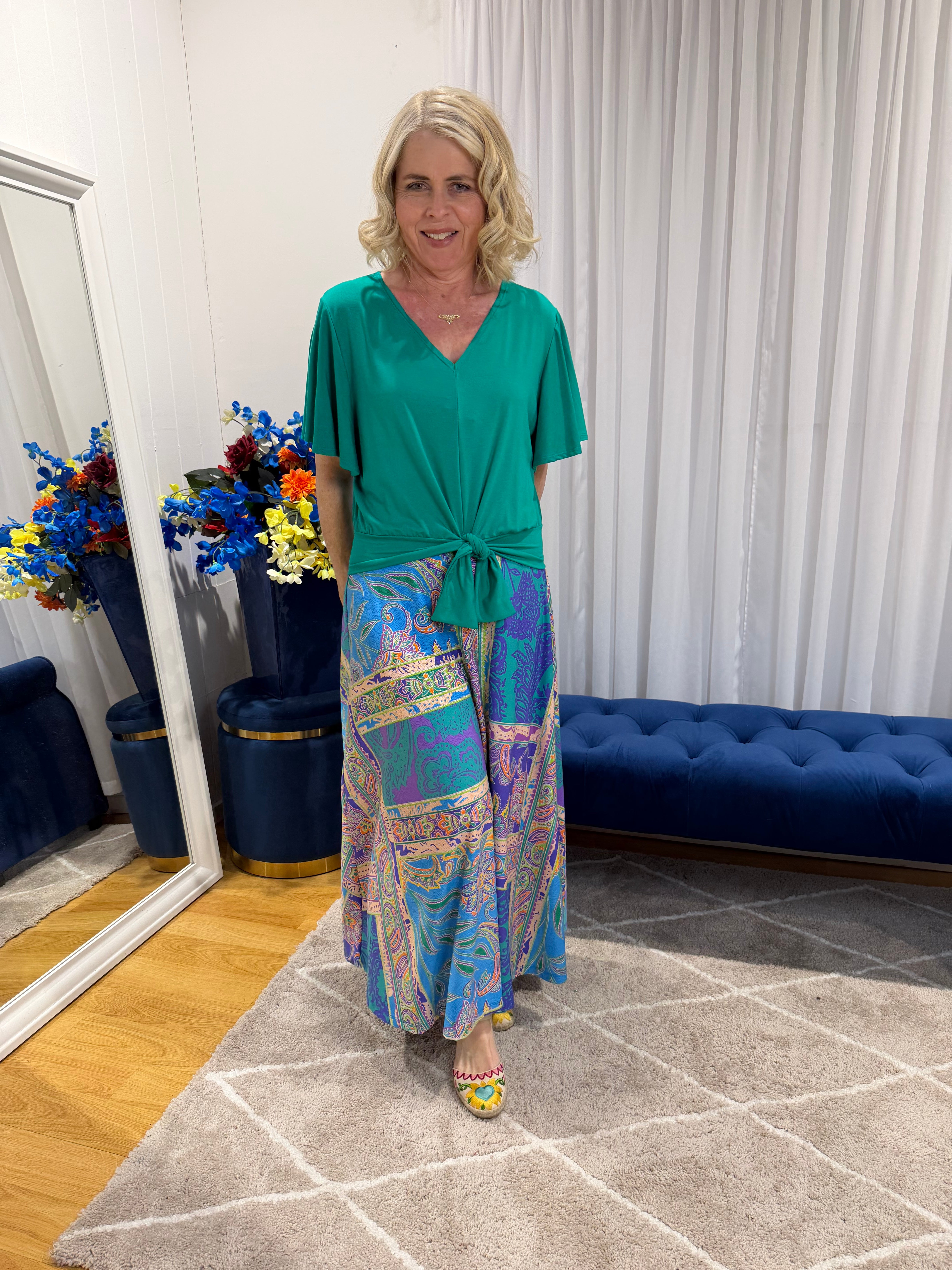 Woman wearing Harper top green and colourful skirt 
