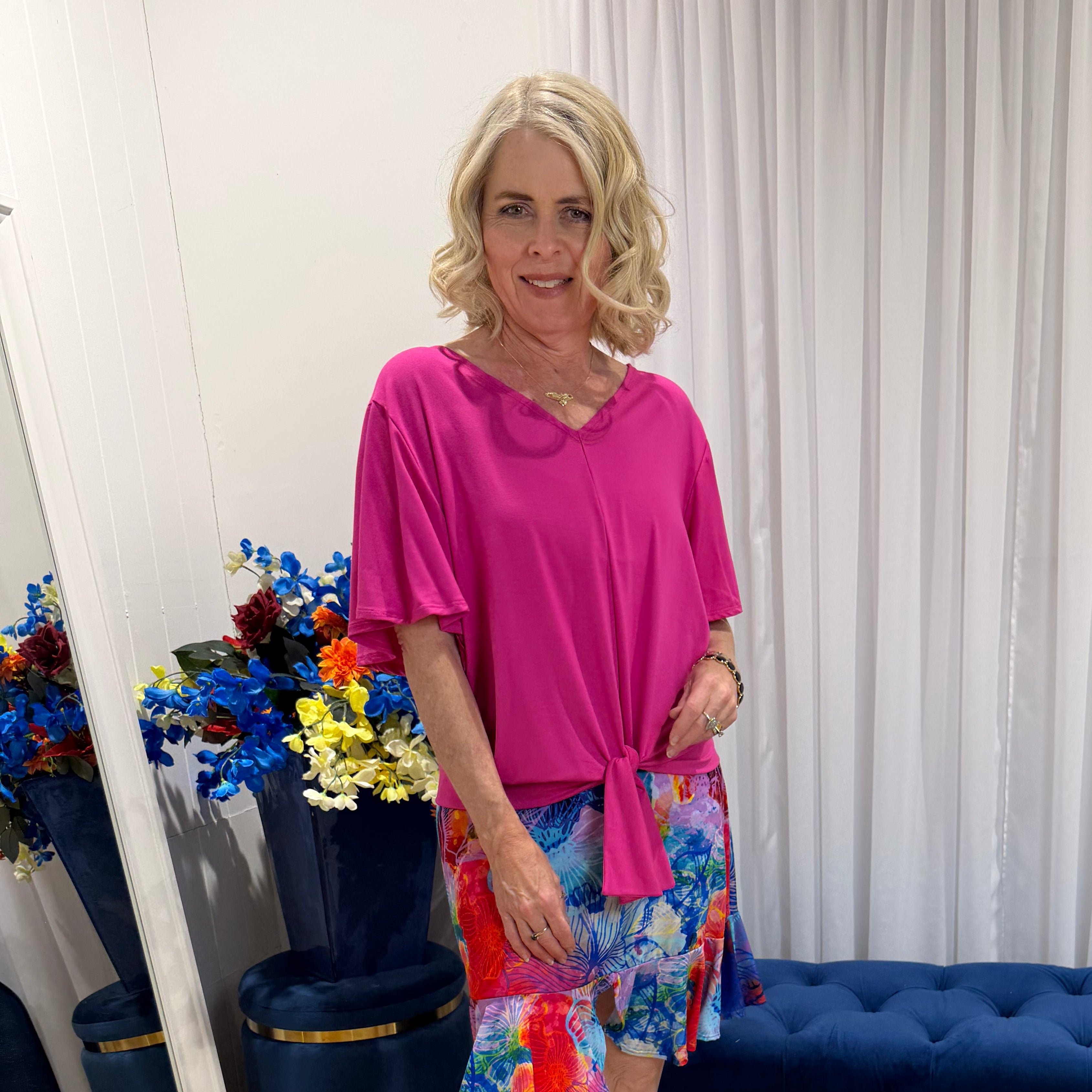 Woman wearing pink top and short colourful skirt 