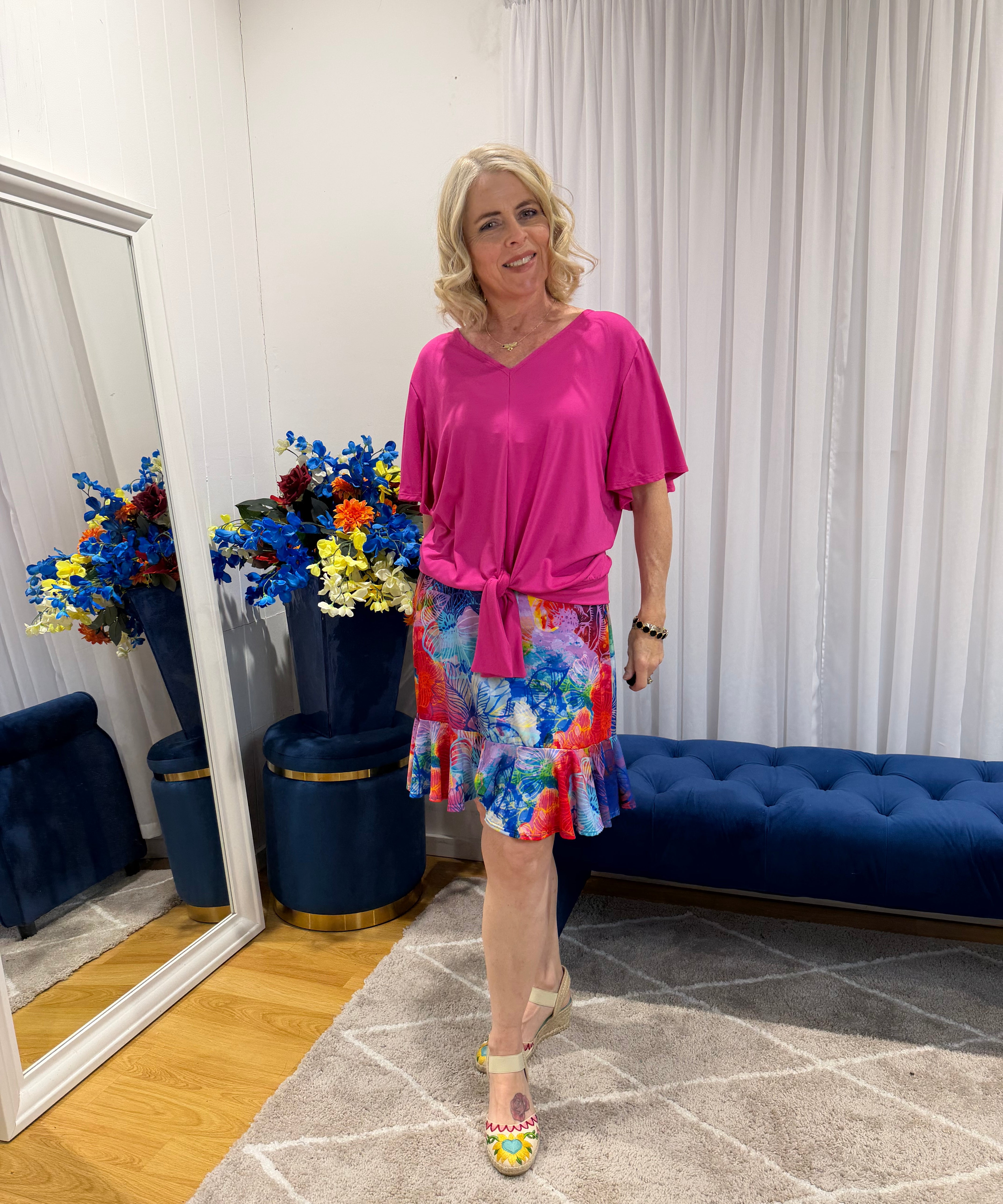 Woman wearing pink top and short colourful skirt 