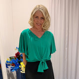 Woman wearing green top and black skirt