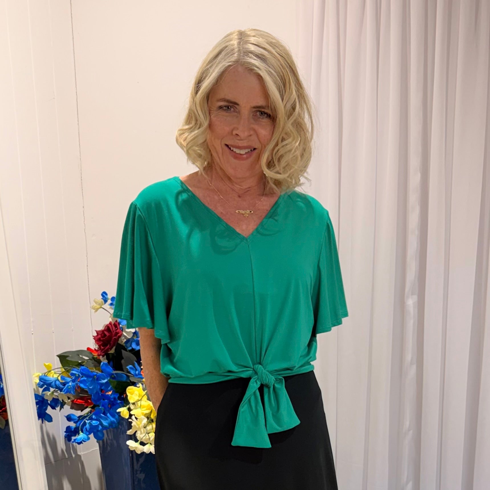 Woman wearing green top and black skirt