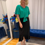 Woman wearing green top and black skirt