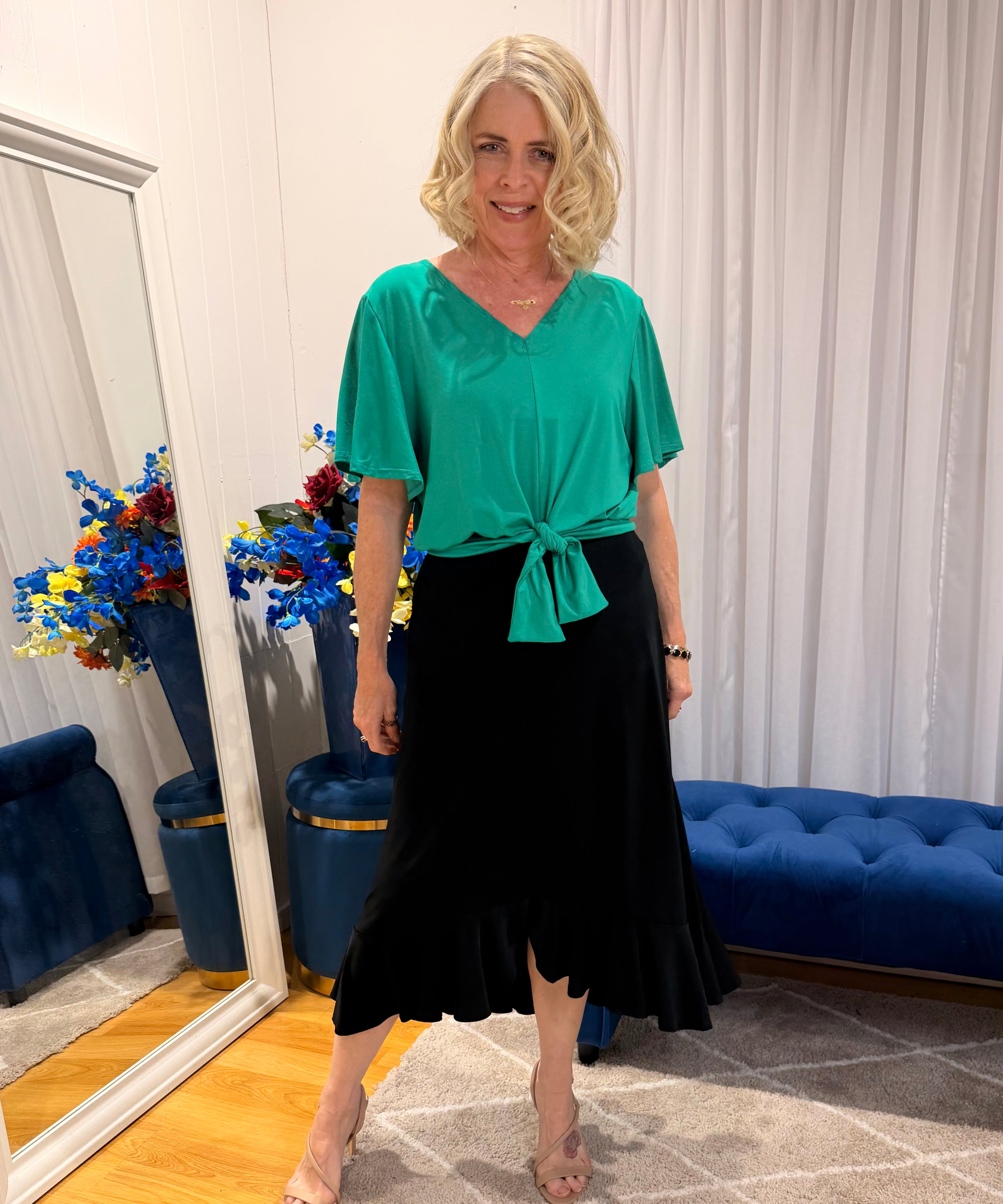 Woman wearing green top and black skirt